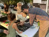 Child learning how to screenprint from a screenprinter
