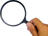 Black magnifying glass being held by a hand on a white background 
