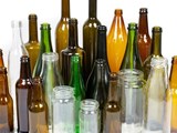 Varying sizes and colors of empty, rinsed glass bottles and jars ready to be recycled