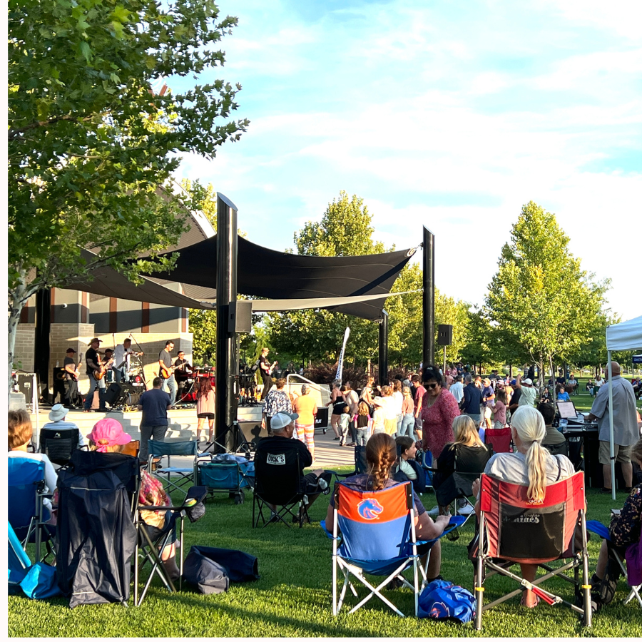 Large crowd sitting in chairs watching band and people dancing in Kleiner park bandshell