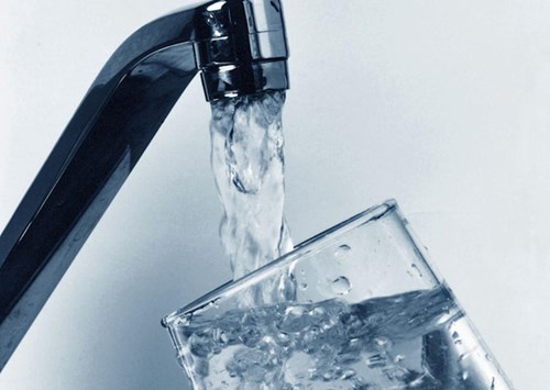 Kitchen faucet filling up a glass with water