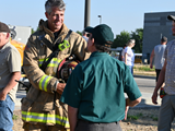 firefighter talking to a community member near a school bus