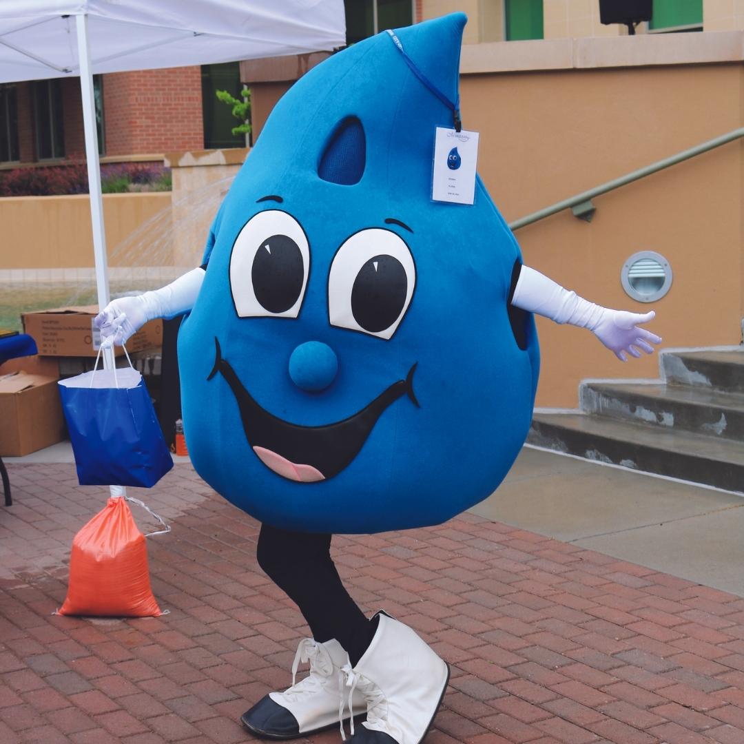 Meridian City Public Works Department mascot, Hydro. Water droplet costume with large eyes and smile.