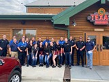 Police Officers and Texas Roadhouse staff standing outside of Texas Roadhouse.